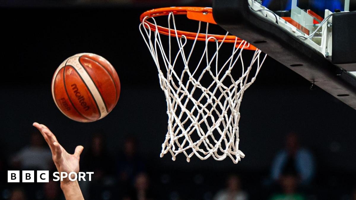 A basketball is thrown towards a net