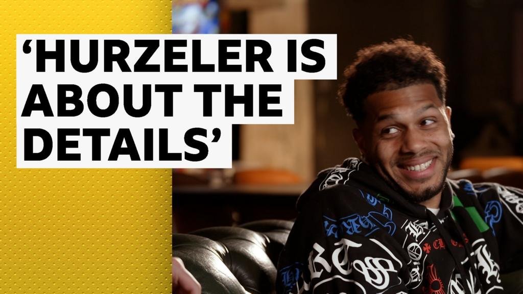 Georginio Rutter sitting on a leather sofa, smiling