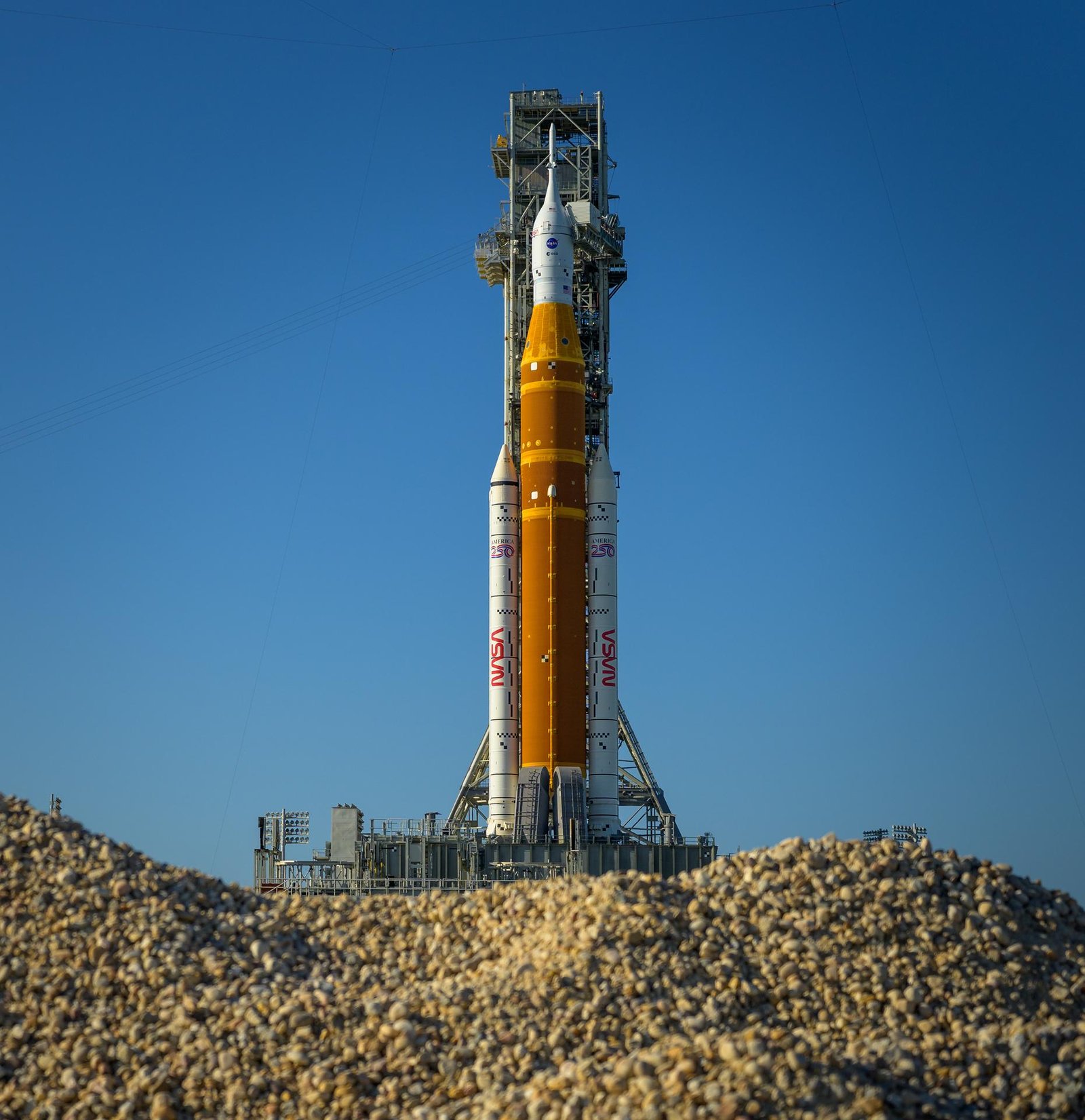 NASA’s Artemis II Space Launch System (SLS) rocket and Orion spacecraft are seen atop a mobile launcher at Launch Complex 39B, Friday, March 27, 2026, at NASA’s Kennedy Space Center in Florida. NASA’s Artemis II test flight will take Commander Reid Wiseman, Pilot Victor Glover, and Mission Specialist Christina Koch from NASA, and Mission Specialist Jeremy Hansen from the CSA (Canadian Space Agency), around the Moon and back to Earth with launch opportunities beginning in April 2026. Photo Credit: (NASA/Bill Ingalls)