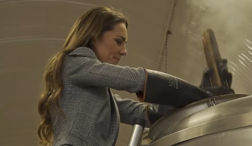 The Princess of Wales wears black gloves to stir a vat of beer