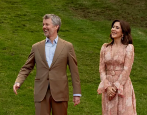 King Frederik and Queen Mary share a laugh as they walk in a garden