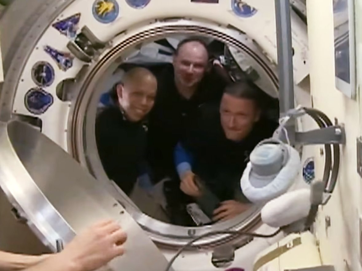 Soyuz MS-28 crew members (from left) Chris WIlliams of NASA and Roscosmos cosmonauts Sergei Mikaev and Sergey Kud-Sverchkov say farewekk to their crewmates before closing the hatch to the Soyuz MS-28 spacecraft.