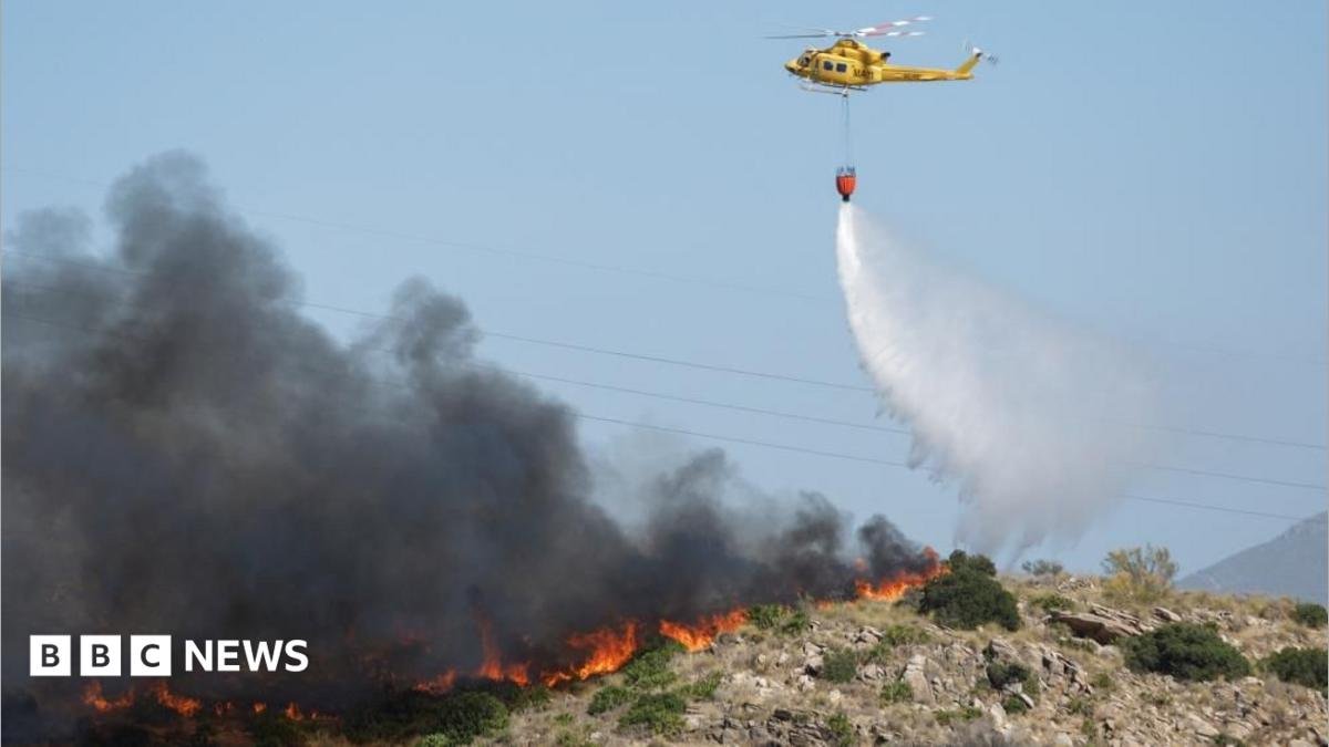 A helicopter works to extinguish flames amid deadly wildfires affecting Almeria province
