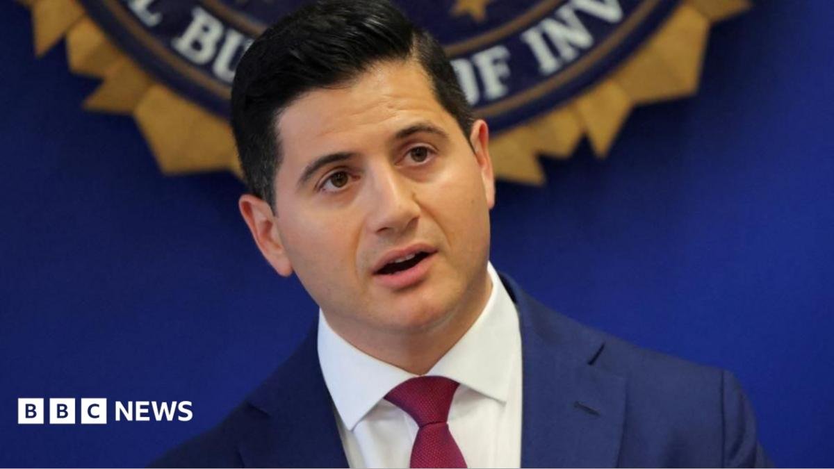 United States Attorney Bill Essayli stands in front of an FBI logo