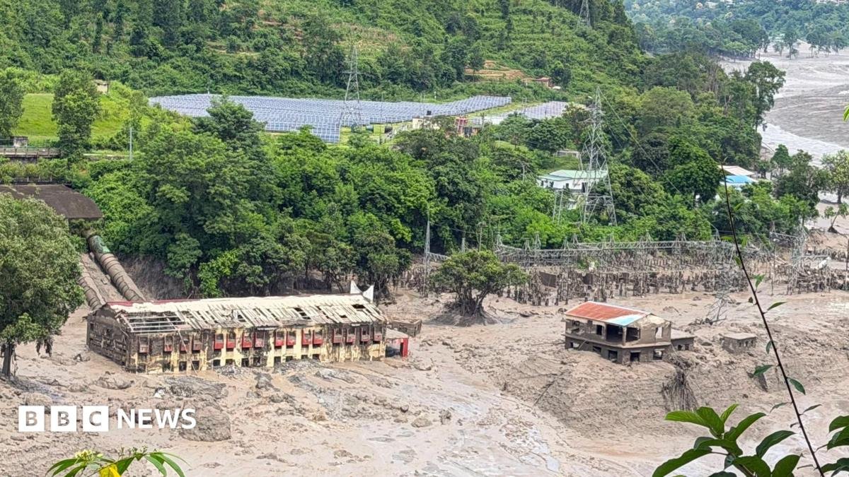 Mud and sand are piled up against a hydropower plant affected by a flash flood in northern Nepal