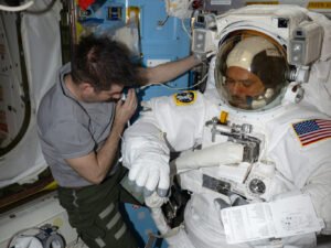 Expedition 75 flight engineer Jack Hathaway assists Expedition 75 flight engineer Anil Menon, both NASA astronauts, inside the Quest airlock as he tried on a spacesuit to verify its comfort, mobility, and functionality. Menon was conducting an on-orbit fit verification of the suit before conducting his first spacewalk outside of the International Space Station.