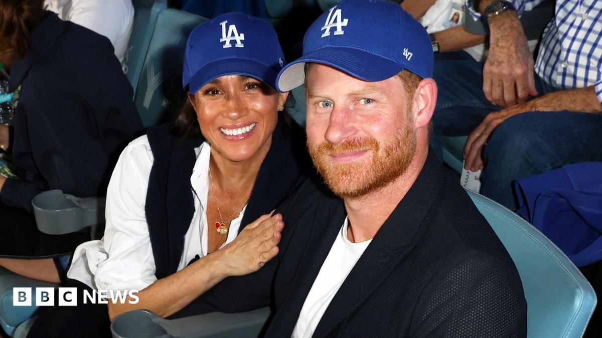 Harry and Meghan smiling next to two others, wearing cocktail attire, at a house