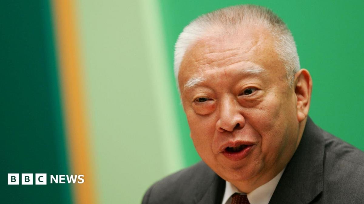 Tung Chee-hwa wearing a dark suit and white shirt